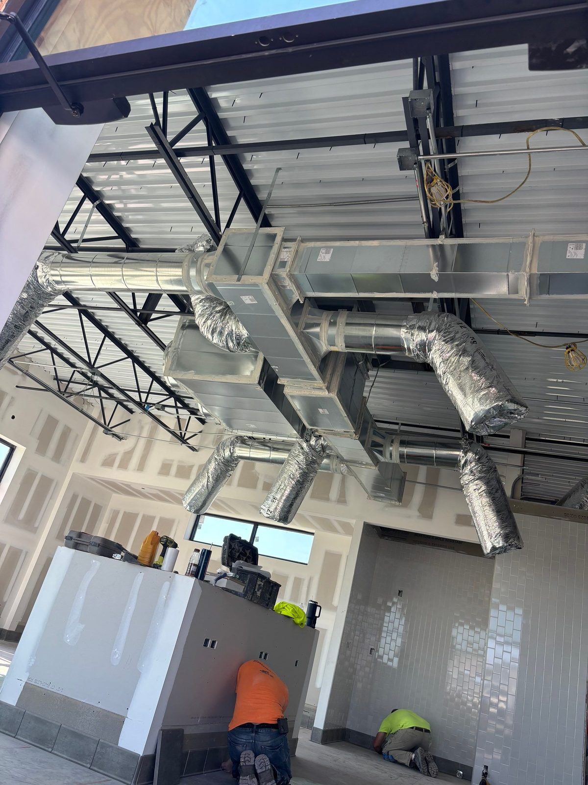 The A/C Ductologist crew installing overhead ductwork on a commercial project